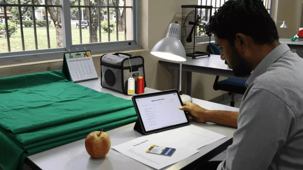 Bangladeshi IELTS learner studying online with notes and a laptop