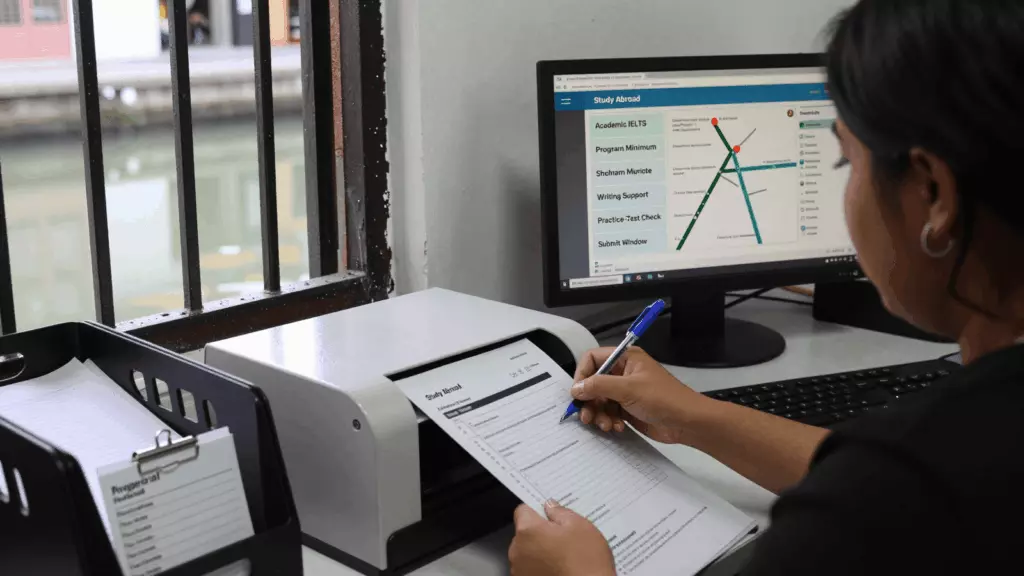 a Latina woman in her late 20s reviewing an IELTS online course workflow