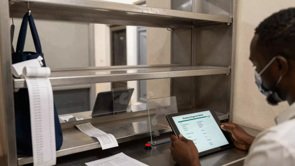 a Francophone African man in his late 20s reviewing an IELTS online course workflow