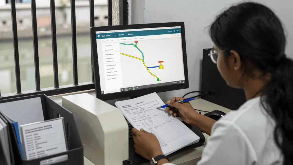 an Indian woman in her late 20s reviewing an IELTS online course workflow