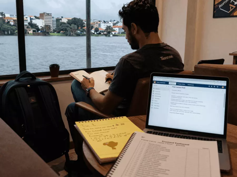 Resposta de escrita do IELTS sendo revisada com notas de tarefas e marcas de correção