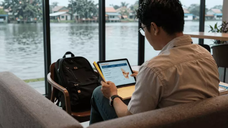 a Thai woman in her late 20s preparing online for วิธีเลือกหลักสูตรออนไลน์ IELTS ที่ดีที่สุดสำหรับคะแนนเป้าหมายของคุณ