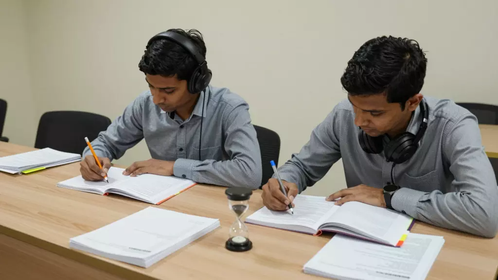 विद्यार्थीले IELTS अभ्यास परीक्षण चलाउँदैछ, हेडफोन अभ्यास परीक्षण र कुनै पनि साथ छैन। टाइमर