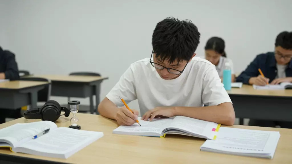 学生使用笔记、耳机和计时器进行雅思考试